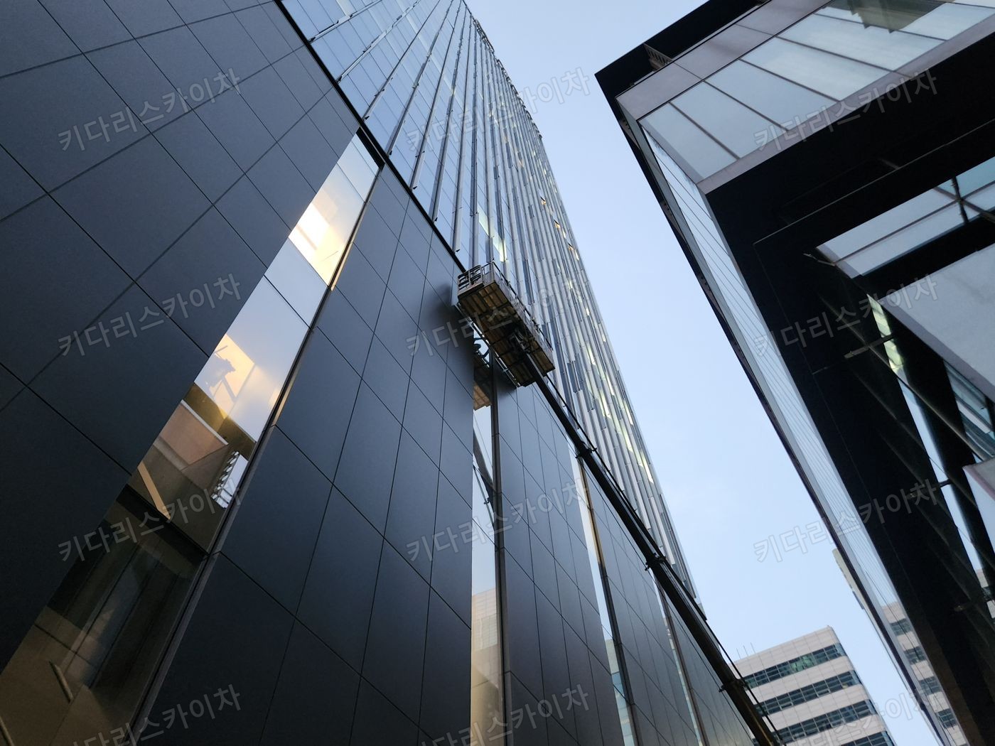 유리 외벽 앞 스카이차 작업대 배치