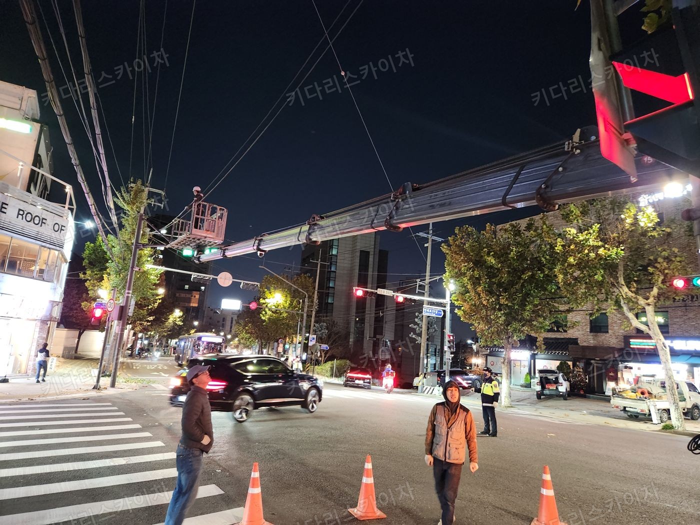 조명이 켜진 상가 외벽 앞 야간 장비 배치