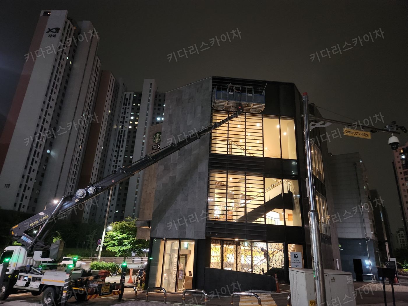 조명이 켜진 상가 외벽 앞 야간 장비 배치