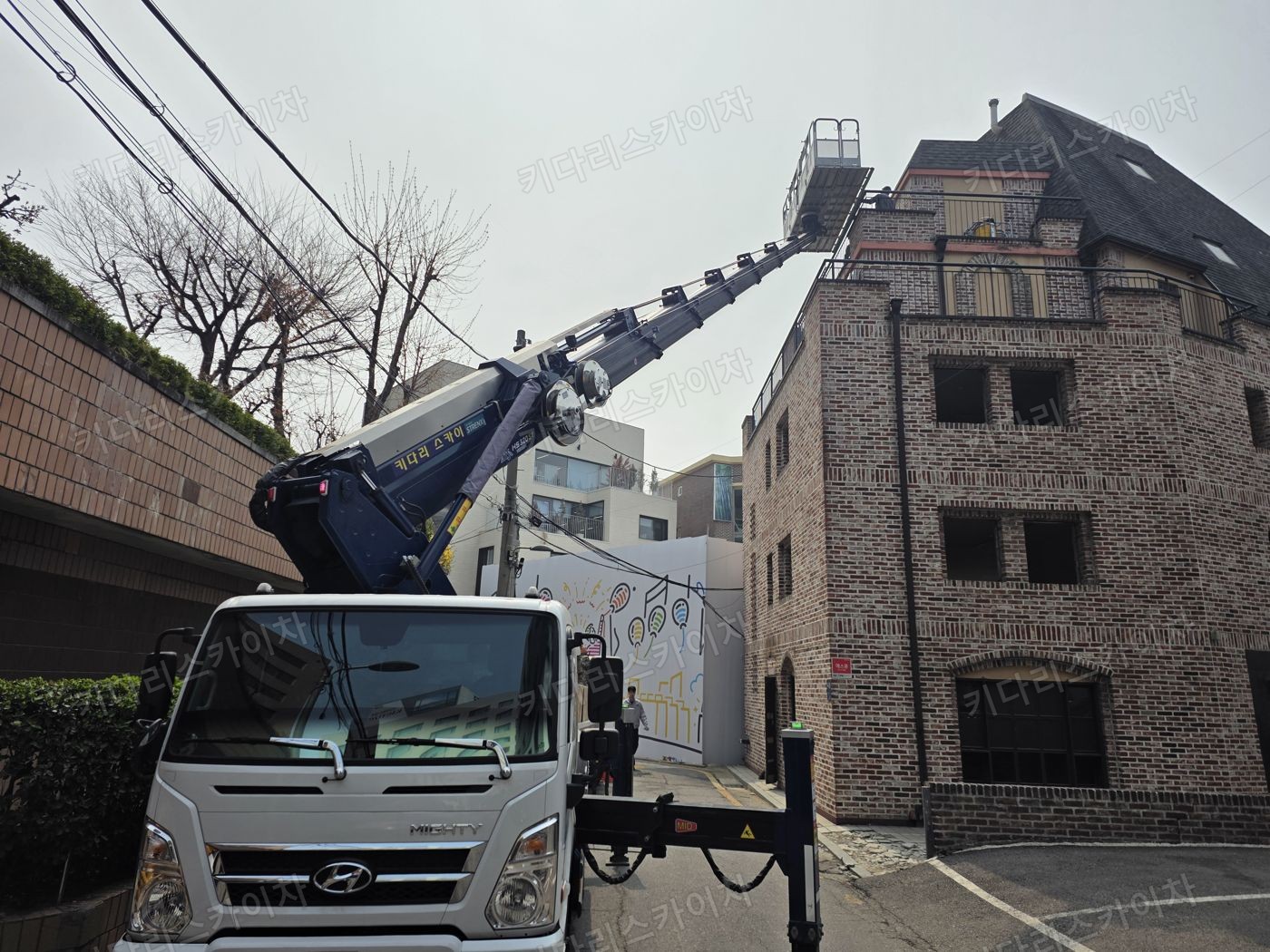 벽돌 건물 앞 스카이차 배치