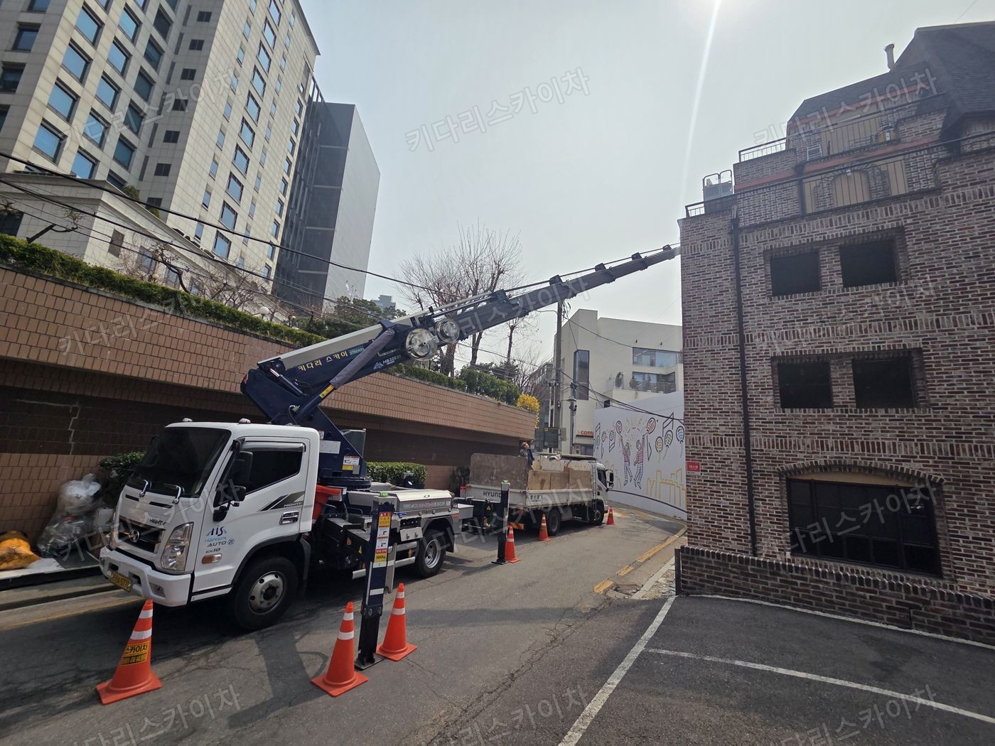 벽돌 건물 앞 스카이차 배치